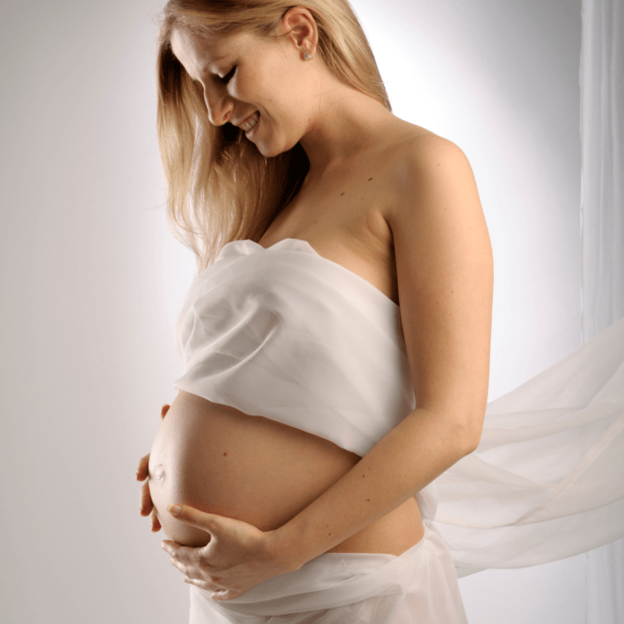 Pregnant woman, happily holding her womb.