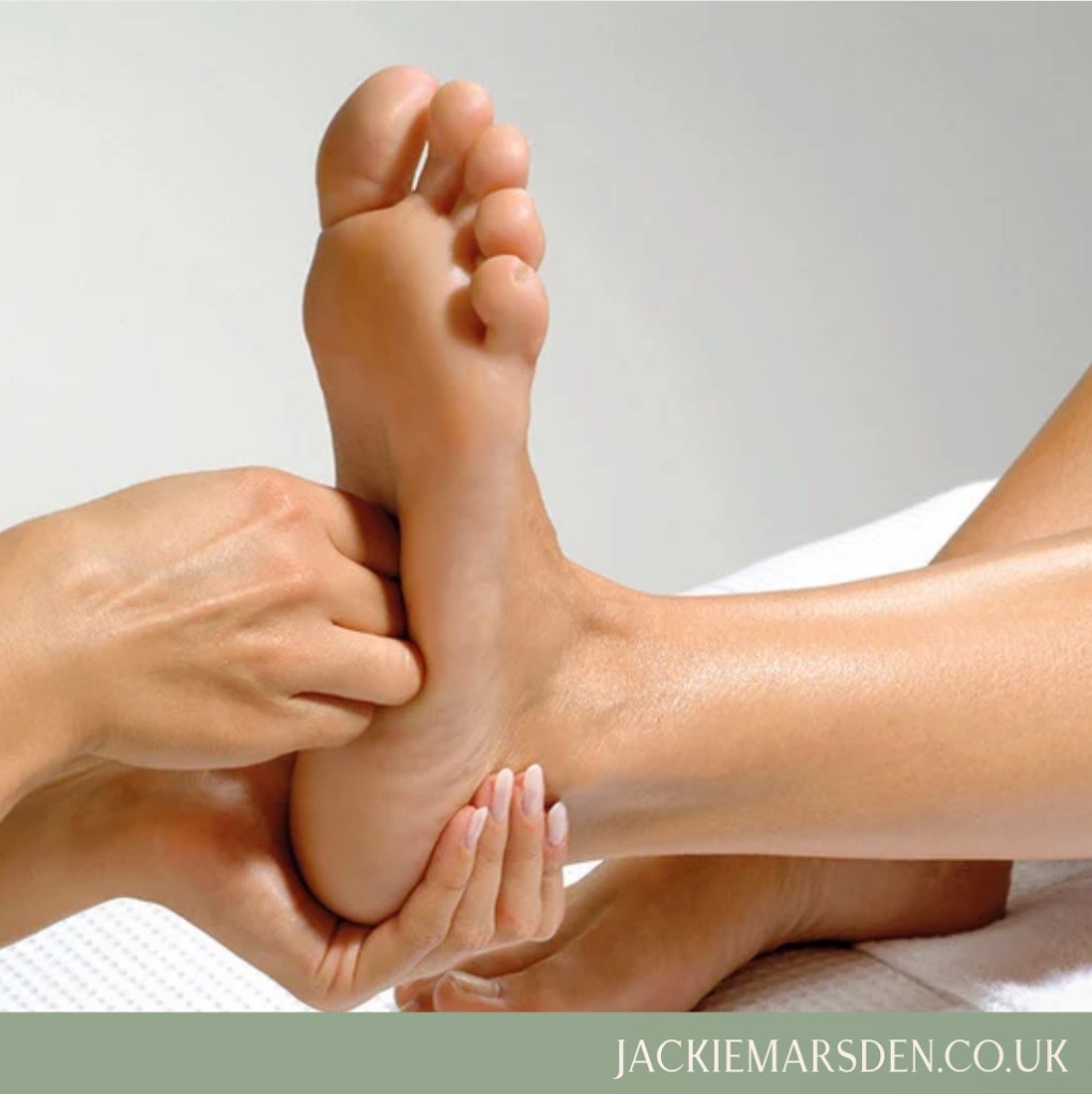 A woman receiving reflexology on her feet.